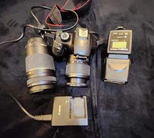 كامرة كانون 1100D مع عدسه اضافيه وفلاش وجميع الاغراض شغاله بدون مشاكل