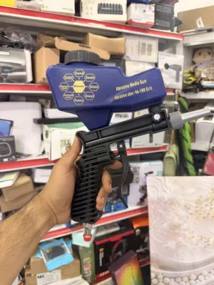 هذا مسدس رملي محمول يعمل بالهواء المضغوط، يُستخدم لتنظيف الأسطح وإزالة الصدأ أو الطلاء.