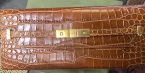 الحقيبة هي حقيبة كلاتش Manhattan من ماركة Saint Laurent الشهيرة، والمصنوعة من الجلد الفاخر