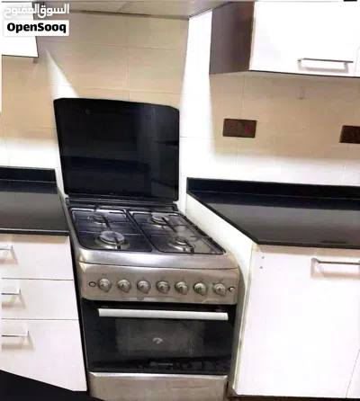 4-burner gas stove with an oven and a gas cylinder. 3