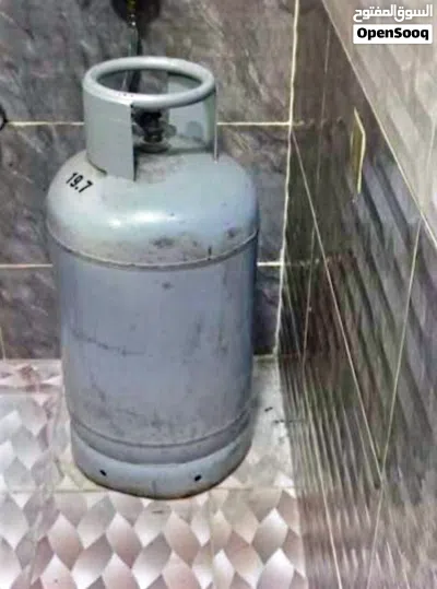 4-burner gas stove with an oven and a gas cylinder. 2