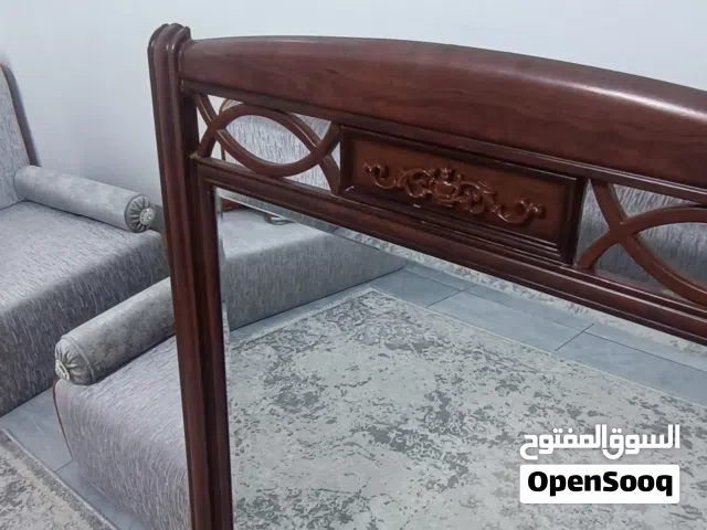 مرآة خشبية أنيقة بتصميم كلاسيكي راقٍ، إطار خشب طبيعي ثقيل بنقوش يدوية دقيقة، تعكس الفخامة والذوق الع