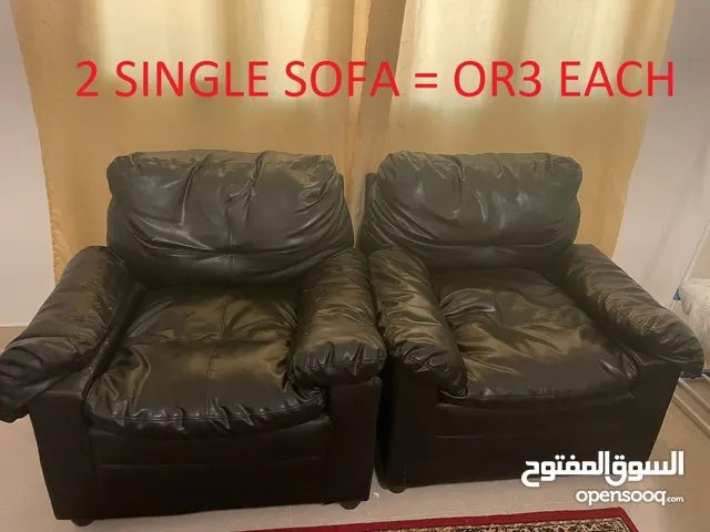 Two single leather look sofas and a one normal three seater sofa and a Turkish carpet.