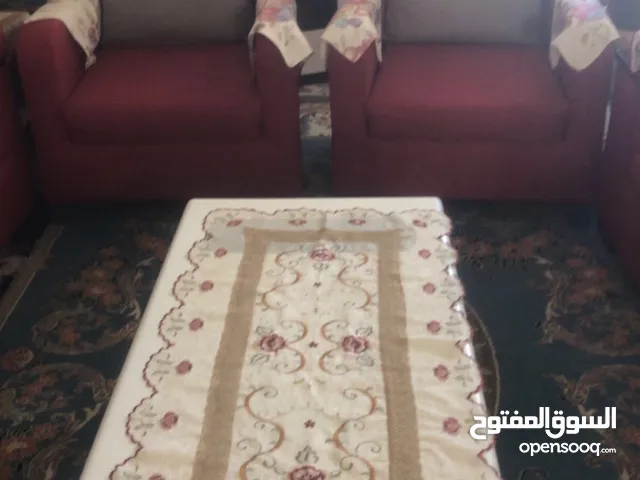 طقم كنب لون احمر و طاولات ستان ستيل و زجاج