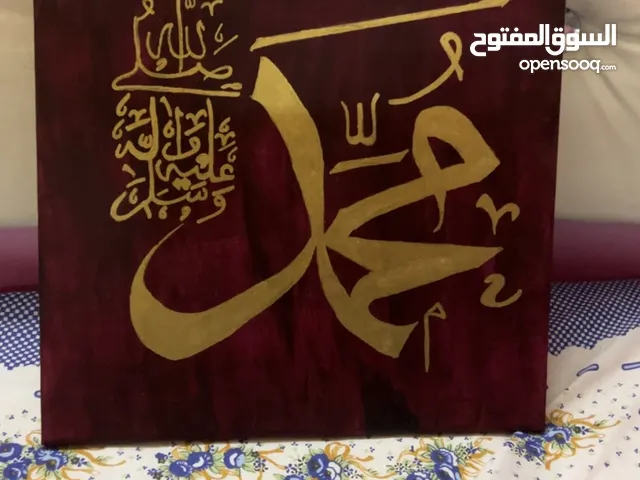 Arabic calligraphy in rich red colour and golden strokes.