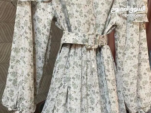فستان بلون البيج ويضاف عليه ورود و اوراق شجر بلون الاخضر