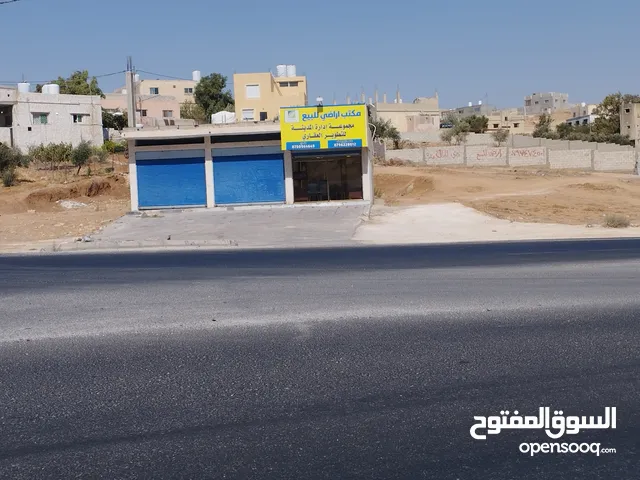 ارض مع مخازن للبيع على الشارع الرئيسي