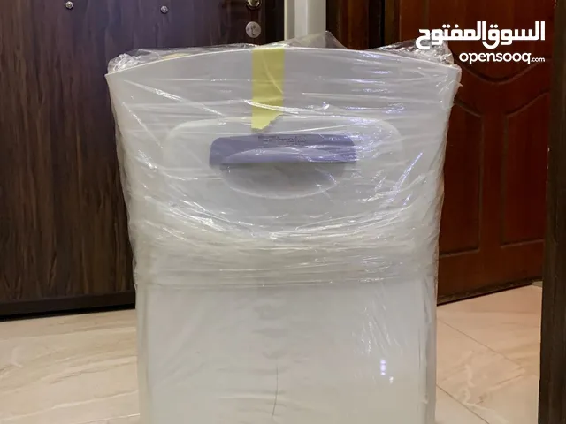 طاولة مكتب لون بيج وكرسي لون اسود وجهاز شفط الروائح وتنقية الجو داخل الغرفة