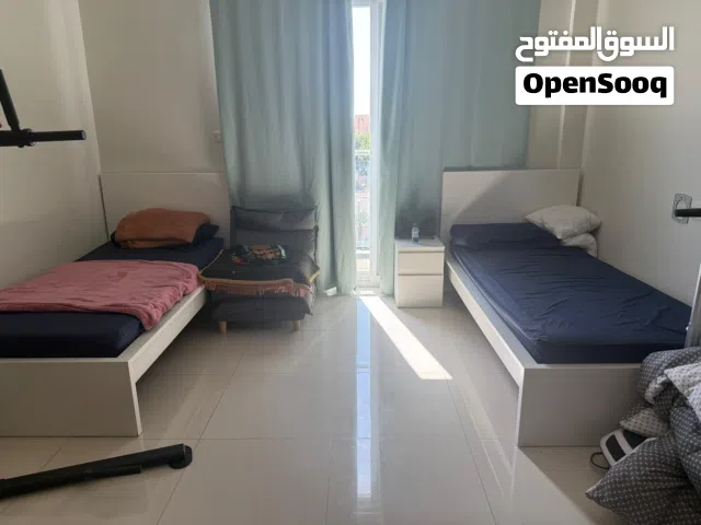 Two 120 cm beds with a bed sheet night stand . سريرين مع الدرج