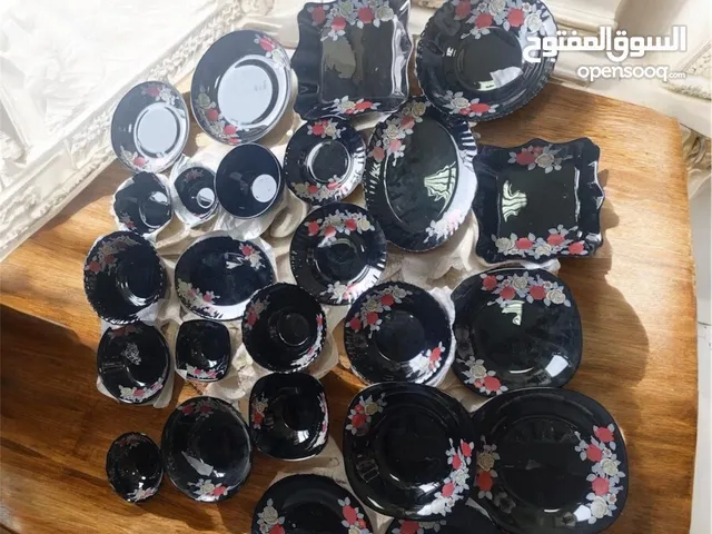 مجموعة أواني الطعام بأحجام وأشكال مختلفه وهيه مصنوعه من مادة زجاجيه سودا اللون ومزينه بنقوش زهور حمر