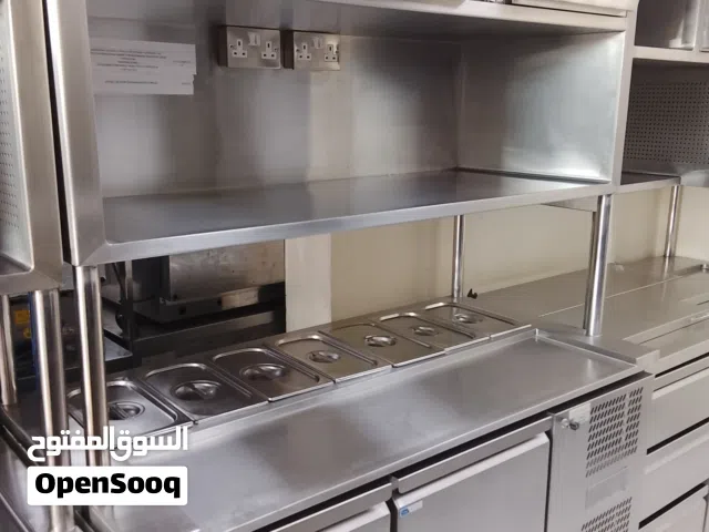 The bottom has a drawer-style refrigerator, and the top has a shelf and storage space.