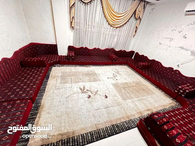 غرفة جلوس مستعمله لون خمري يدخل فيها تطريز نقوش باللون الذهبي تصميم خاص