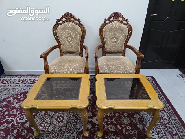 Two wooden chairs with two coffee tables in riffa