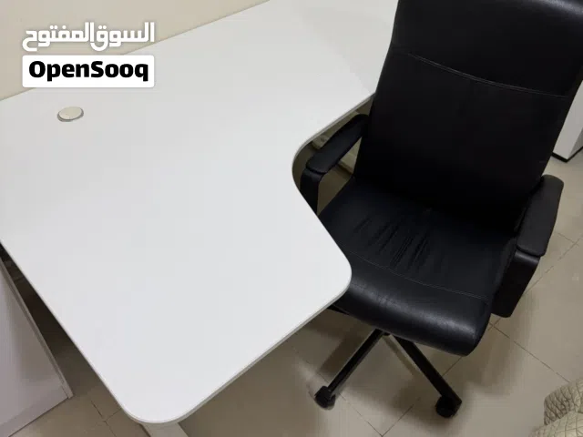 طاولا بلون ابيضّ جانبيه حجم كبير مع كرسي بلون اسود