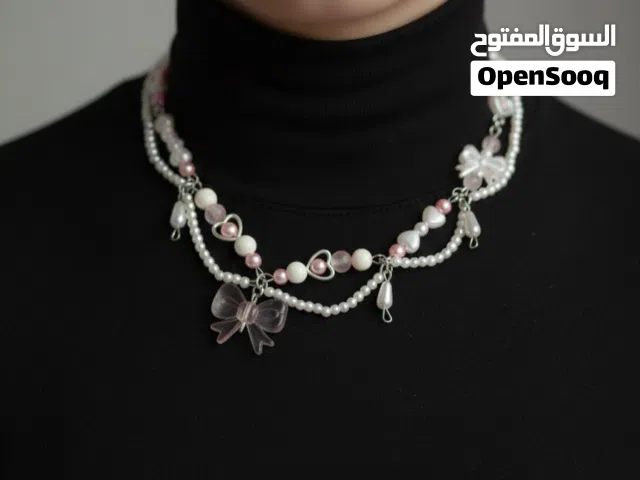 هذه القلادة مصممة بأسلوب أنثوي وناعم يجمع بين اللؤلؤ الصناعي والخرز الوردي والأبيض.