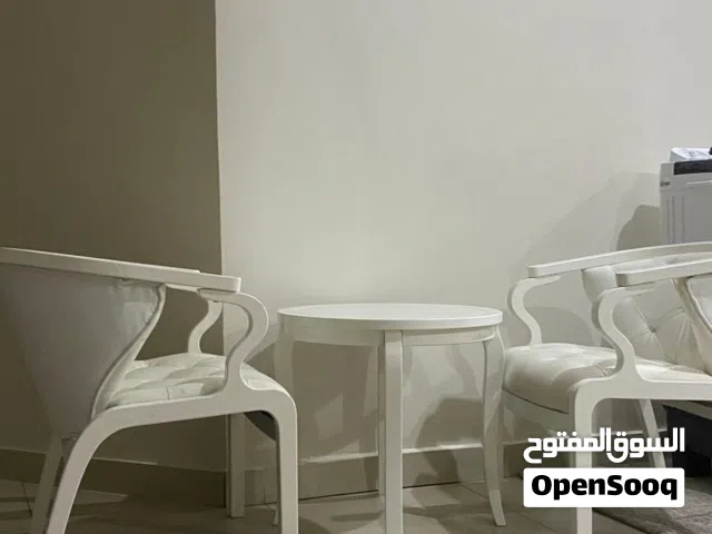 طاولة بيضاء مع كرسيين مريحين