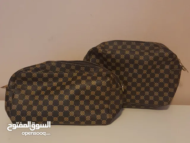 Brown and golden purses with circles and a mini flower design in them