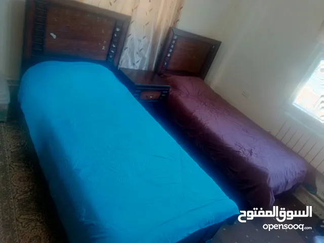 غرفة نوم شبابية سريرين مع كومودينة