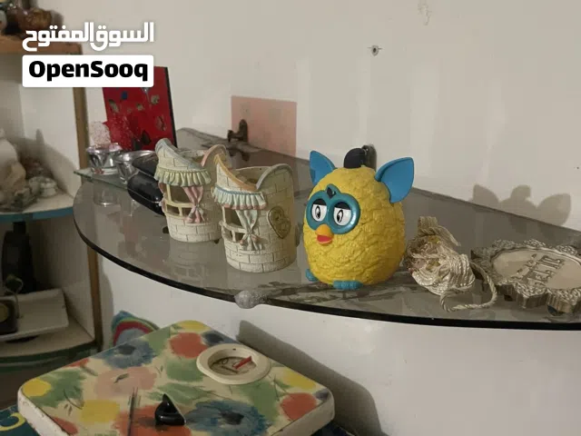 رف زجاجي عائم  بتصميم نصف دائري مثبت بزوايا معدنية  على الخائط مزهريات وتحف زجاجية فاخرة