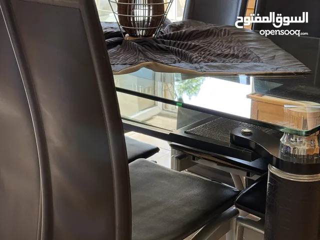 غرفه جلوس جلد وقماش اللون بني وطاوله سفره جلد وزجاج