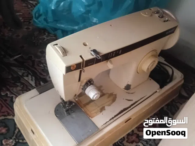 ماكينة خياطة سنجر توضع على الطاوله  وهي تشتغل على الرجل