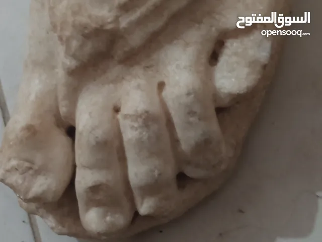 عملة قديمة + أثر لقدم إلاه إغريقي
