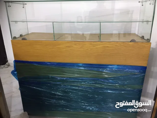 كاونتر خشبي مع زجاج وعجلات.