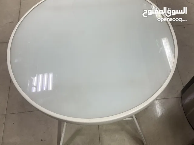a small round table likely a side table folding table/white bistro table