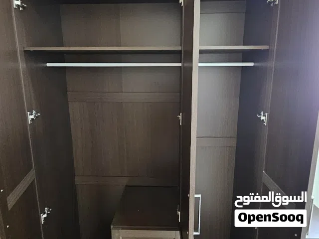 للبيع خزانة (دولاب) ملابس (Wardrobe) خشبية ذات تصميم أنيق ولون بني داكن.