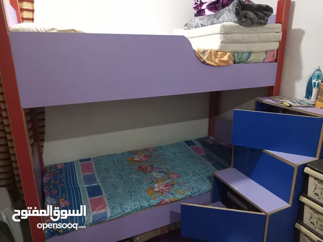 سرير أطفال طابقين مع درج فيه كبتات