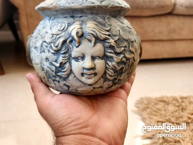مزهرية عتيقة مزخرفة بوجه - لمسة من التراث في منزلك
