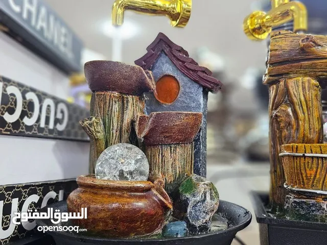 نافورة ديكور خشبية وفخارية بتصميم فاخر    حنفية ذهبية أنيقة يتدفق منها الماء بانسيابية.  قاعد