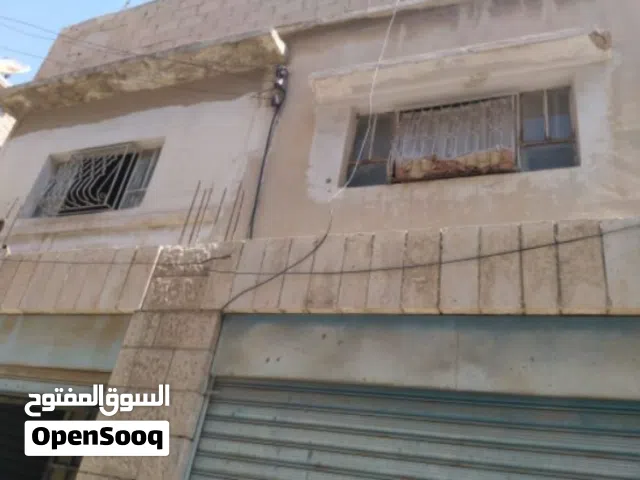 فرصة استثمارية في الزرقاء: أرض + 4 مخازن و3 شقق مجاناً!