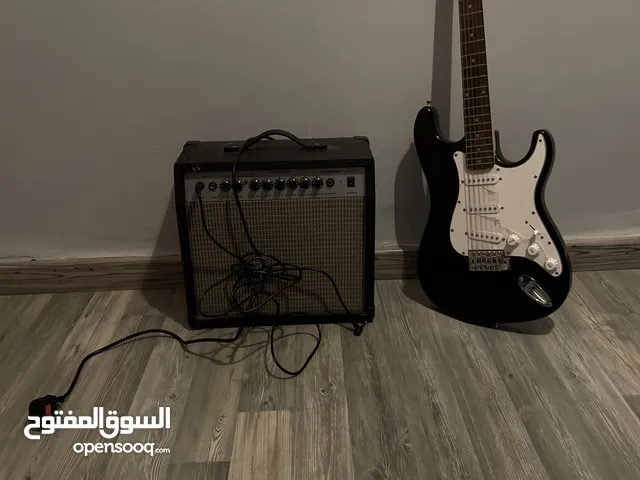 Electric guitar(Black and white) and Amplifier.  غيتار كهربائي(اسود و ابيض) و مكبر للصوت