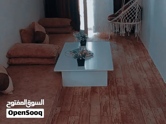 غرفة جلوس وكنب وطاولات وفرشتين مفرد مع طاوله وسط وغرفة نوم
