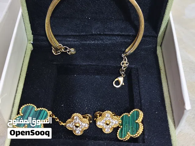 Van Cleef & Arpels bangle & Magic Alhambra earrings features a delicate yellow gold band punctuated