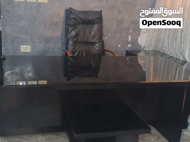 مكتب كبير مع طاولة جانبية وكرسي مكتب وطاولة خدمة صغيرة