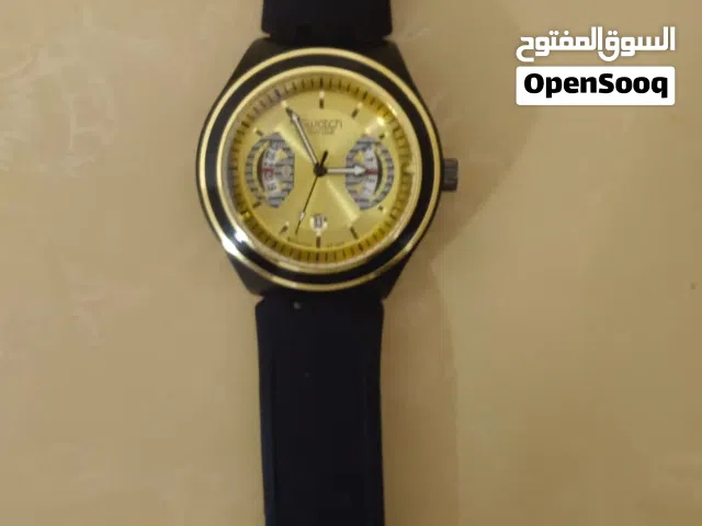 ساعة Swatch Irony أصلية بتصميم قديم، مع سوار مطاطي وواجهة ذهبية.