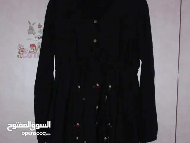 فستان نسائي قصير بقصة واسعة على الخصر، بلون أسود سادة، ومطرز بالورود