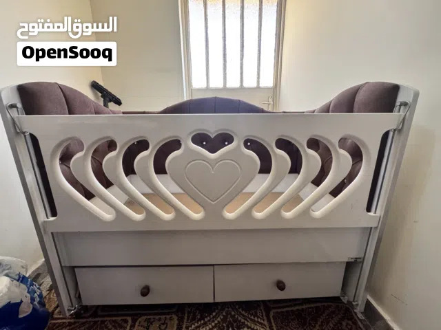 سرير طفل يحتوي على دوشمة جانبية