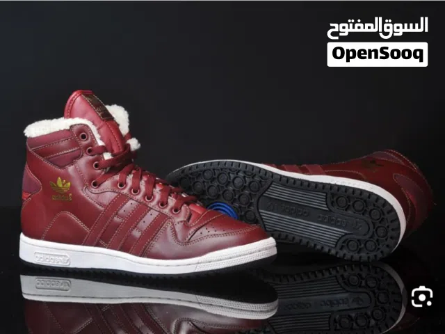 حذاء Adidas Originals Decade OG Mid باللون الأحمر الماروني مع تفاصيل ذهبية وبطانة داخلية من الفرو ال