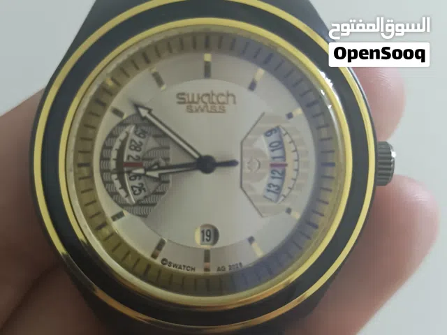 ساعة Swatch أصلية بحالة جيدة، تصميم مميز وأنيق باللون الأسود مع إطار ذهبي.