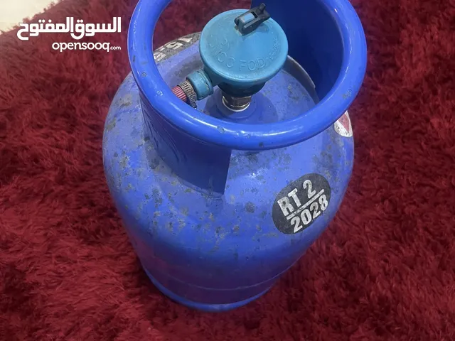 اسطوانة غاز مع المنظم وفي نصها غاز Gas cylinder with regulator and contains half gas
