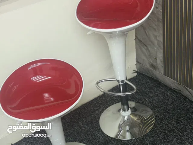 كرسي بار أحمر وأبيض بتصميم أنيق، ثابت وقوي، يمنح جلوساً مريحاً ولمسة راقية وتناسق ألوان يخطف الأنظا