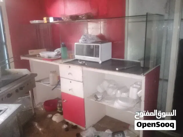 دولاب عرض خشب كبير رفوف وادراج وزجاج لون ابيض مخطط احمر و طاولتين بلاستيك دائري