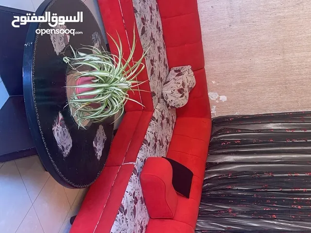 غرفة جلوس كبيره حمراء ويوجد معها كوشانات زياده ومساند تعتبر 18 مقعد ضهر باللون الاحمر والمقاعد معرقه