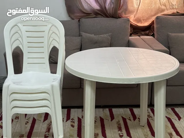 four plastic chairs and a plastic Table