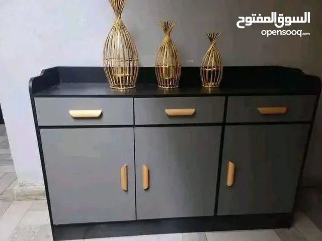 خزانة بتصميم راقٍ يجمع بين العملية والجمال، بلون رمادي أنيق ولمسات سوداء، مع مقابض ذهبية تضيف فخام