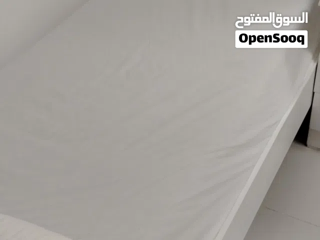 A single white wooden bed for one person.