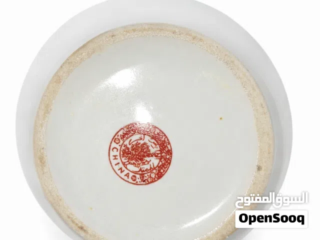 إبريق قديم مزخرف بزخارف ملونة دقيقة تشمل الطاووس والزهور ونقوش تقليدية. أسفل القطعة يوجد ختم أحمر
